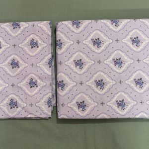 Lavender printed cotton bedsheet set on wooden bed with matching pillow covers