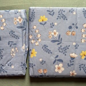 Dusty blue floral print cotton bedsheet set on wooden bed with matching pillow covers
